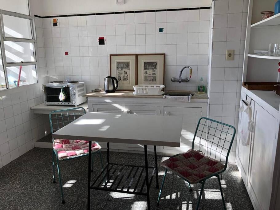 a kitchen with a table and two chairs in it at Cómodo apartamento en Colonia, cerca de todo in Colonia del Sacramento