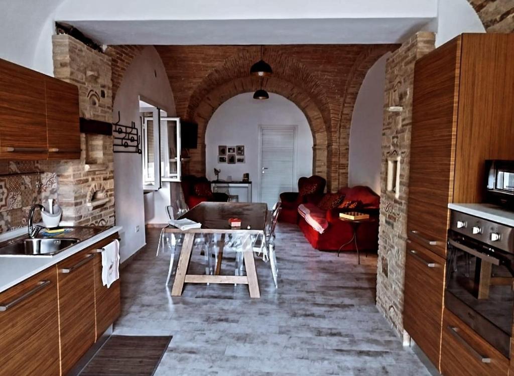 uma cozinha e sala de estar com uma mesa e um sofá em La Taverna del Marchigiano em SantʼEusanio del Sangro