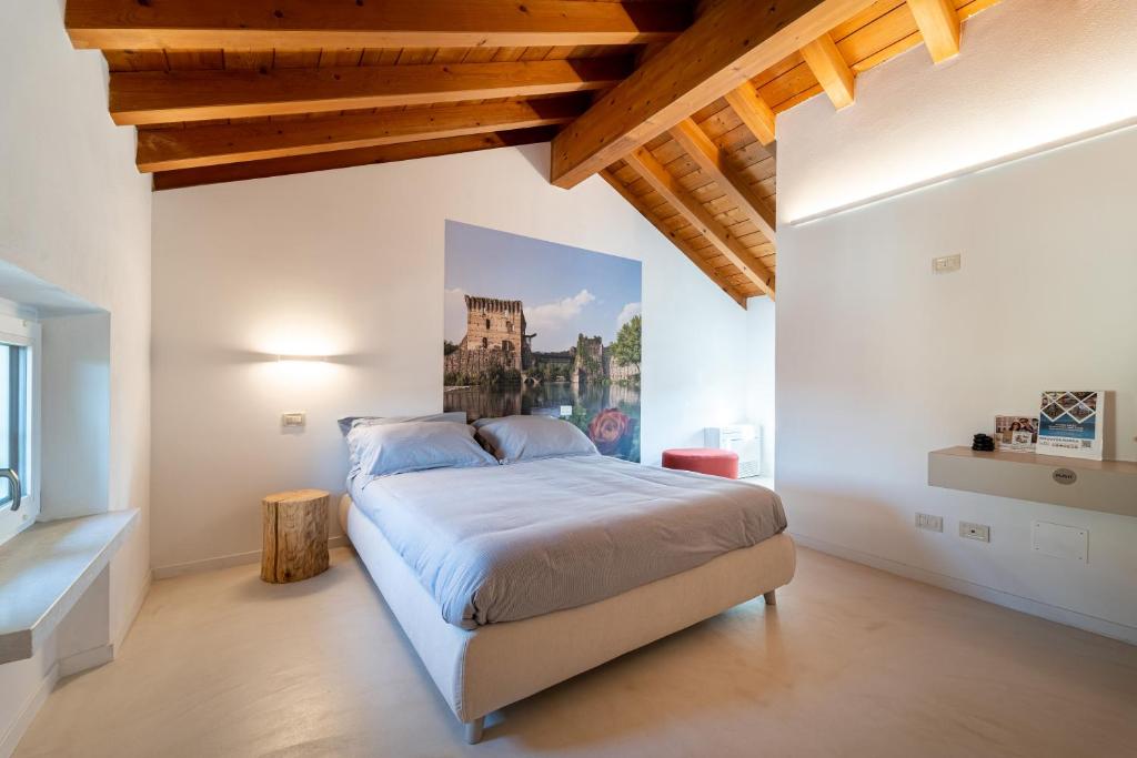a bedroom with a large bed with a wooden ceiling at Una Rosa sul Mincio in Valeggio sul Mincio
