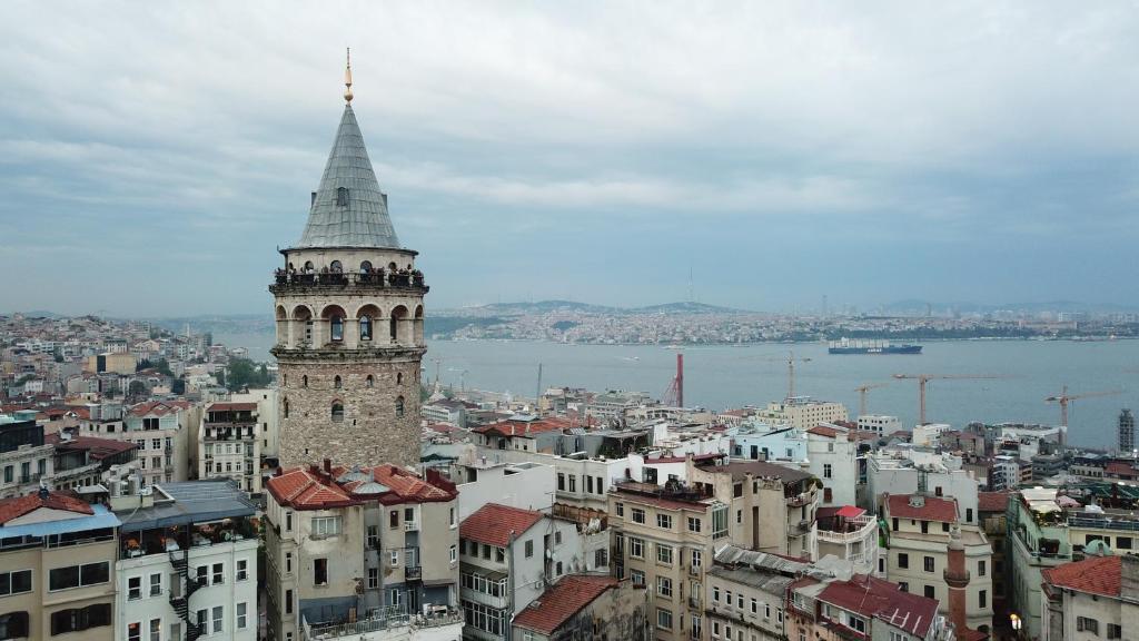 wysoki budynek z wieżą na szczycie miasta w obiekcie Galapera Hotel w Stambule