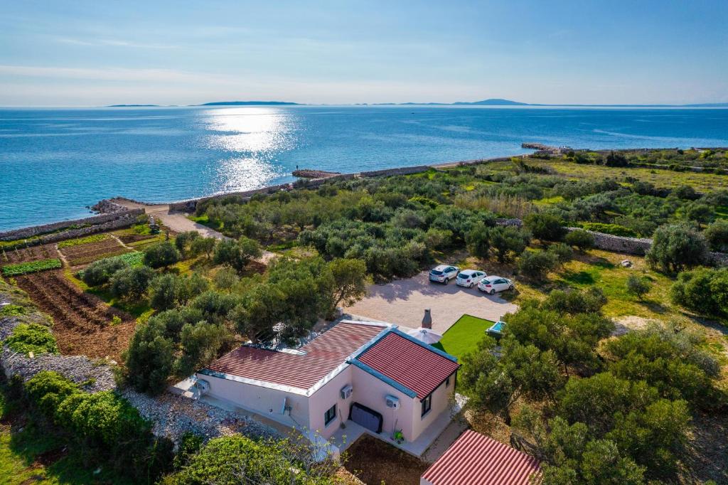 uma vista aérea de uma casa com o oceano em Villa Grioni, beach front villa with jacuzzi em Novalja