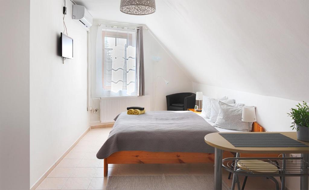 - une chambre avec un lit, une table et une fenêtre dans l'établissement Valentin ház, à Szentendre
