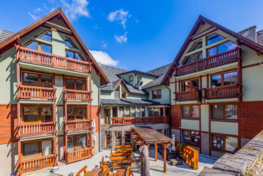 a group of buildings with a picnic table in front of them at Apartmánový dom Fatrapark 1 s Wellness - Hlavná recepcia in Ružomberok