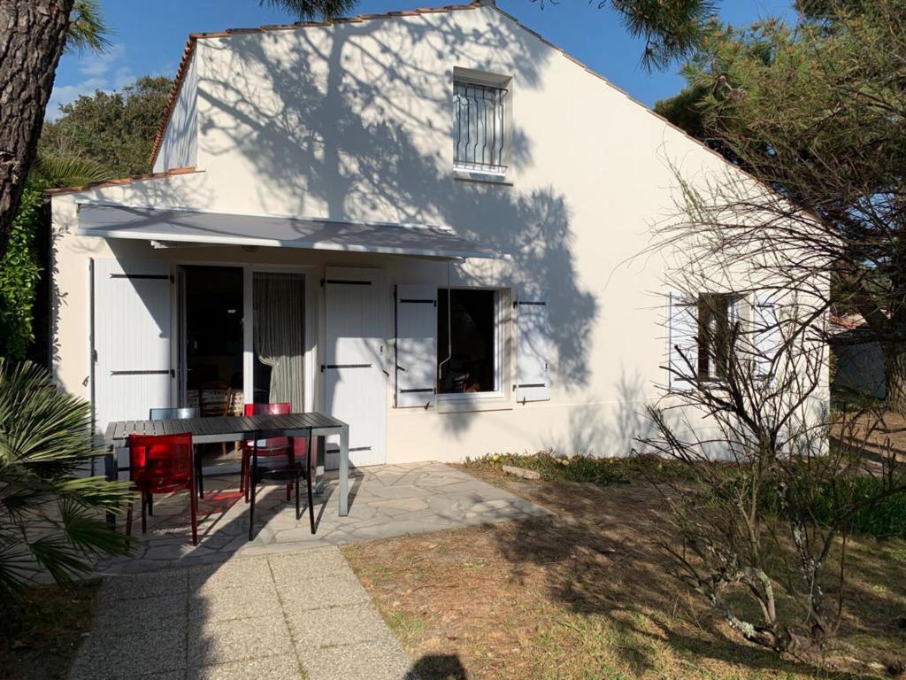 a white house with a table in front of it at Mon Dada 150m de la plage, climatisee in Saint-Georges-dʼOléron
