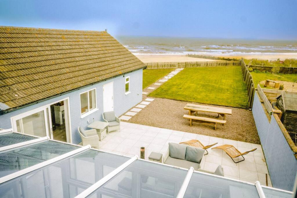 an aerial view of a house with a patio and the beach at Seaview Beach House in Norwich