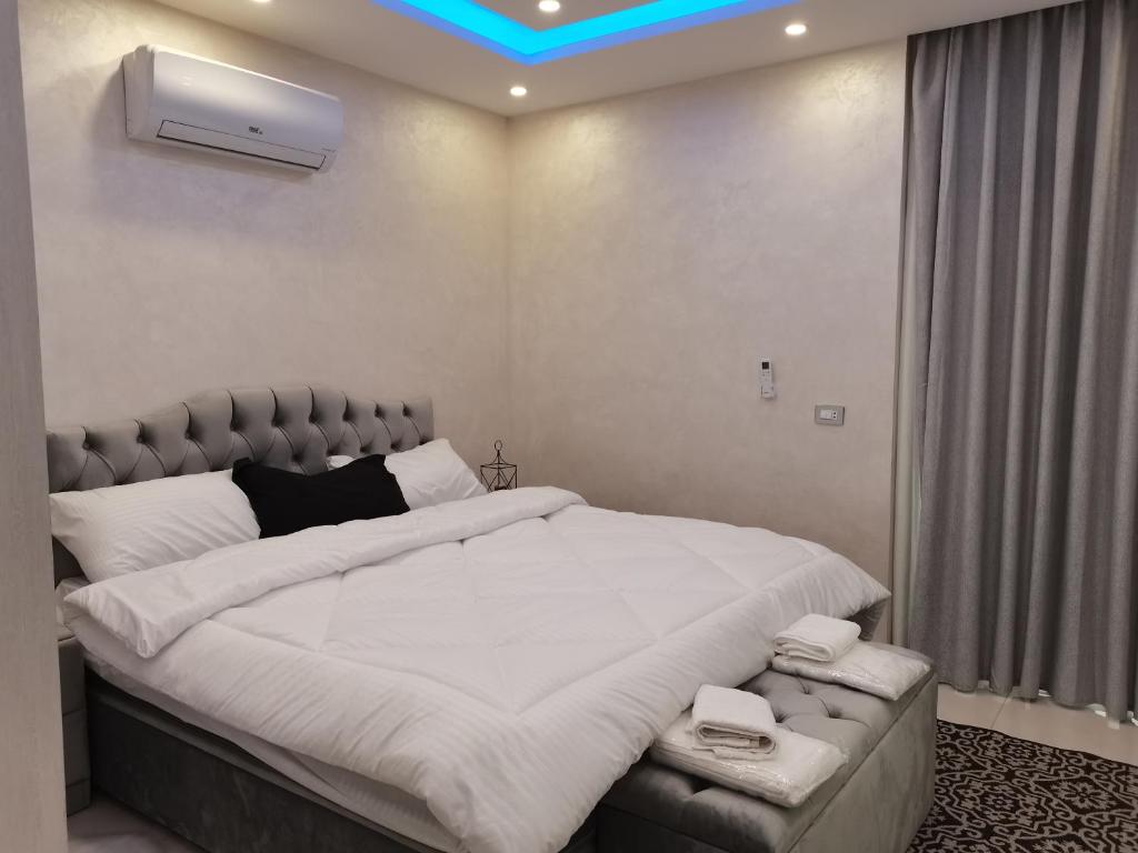 a bedroom with a large bed with white sheets at The Legend Villa فيلا الاسطوره in Sowayma