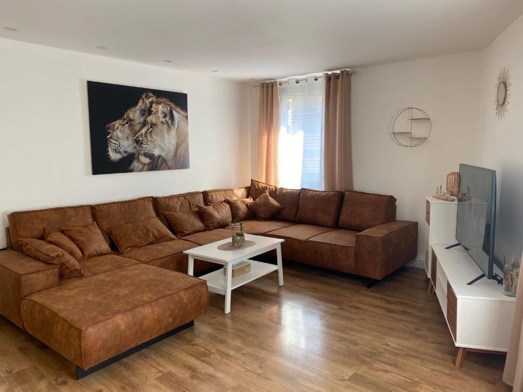 uma sala de estar com um sofá castanho e uma mesa em Ferienwohnung Auszeit em Bad Kreuznach