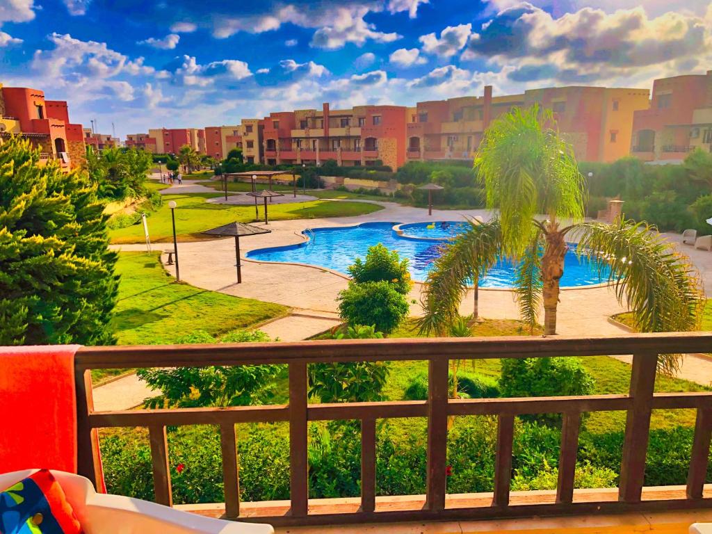 - une vue sur un complexe avec une piscine et des palmiers dans l'établissement شاليه جديد عائلي كبير, à Dawwār al Ḩajj Aḩmad