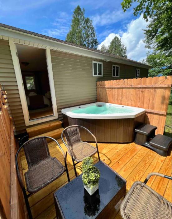 a patio with a hot tub and chairs and a table at Mountainscape Cabins 1 in Thornton