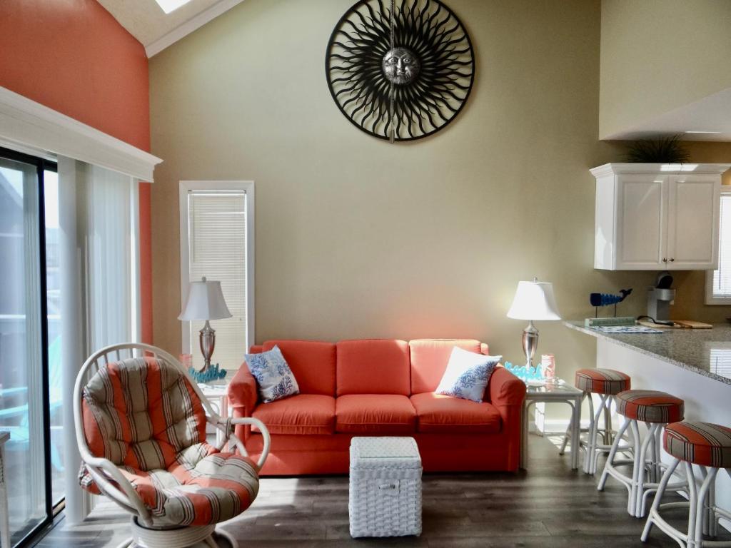 a living room with a red couch and chairs at Coral Cottage-3B GCR in Myrtle Beach