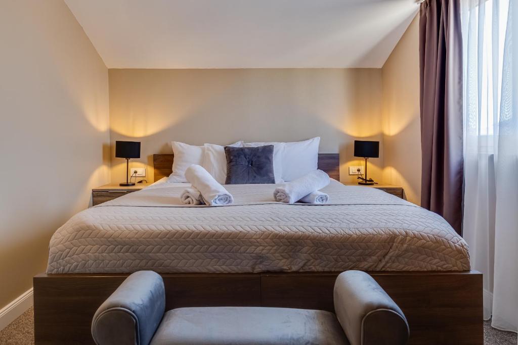 a bedroom with a large bed with two lamps at Hotel Sky in Zadar