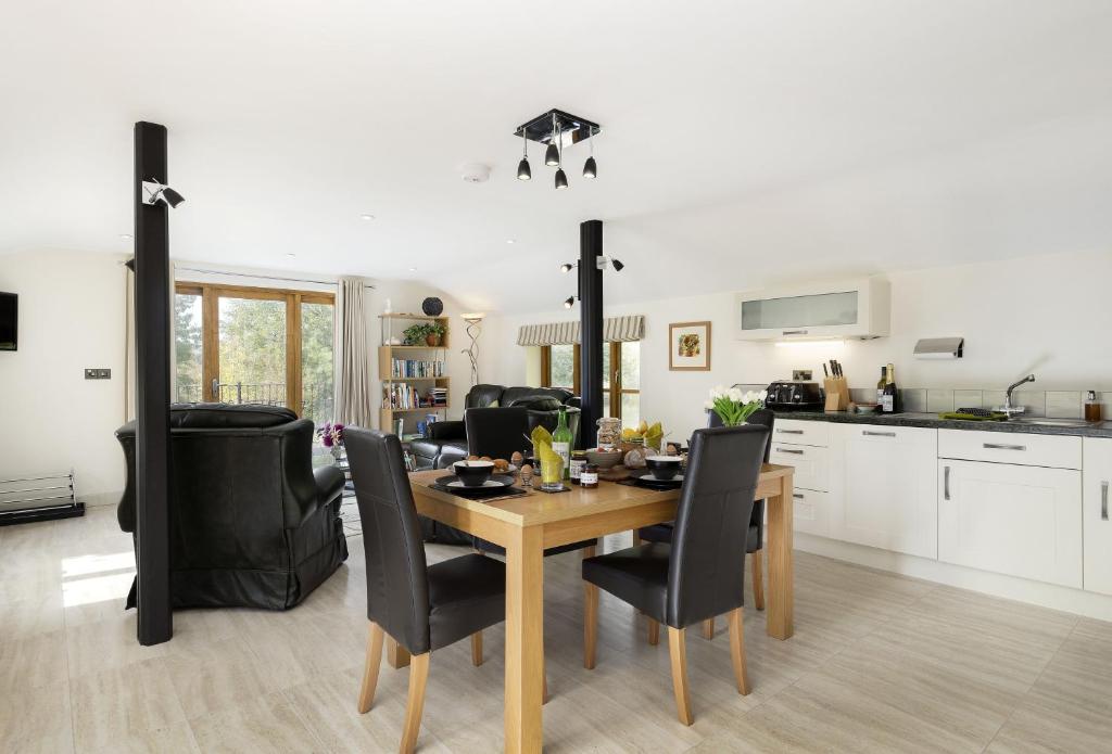 a kitchen and dining room with a wooden table and chairs at The Coach House at The Old Rectory in Stoke Prior