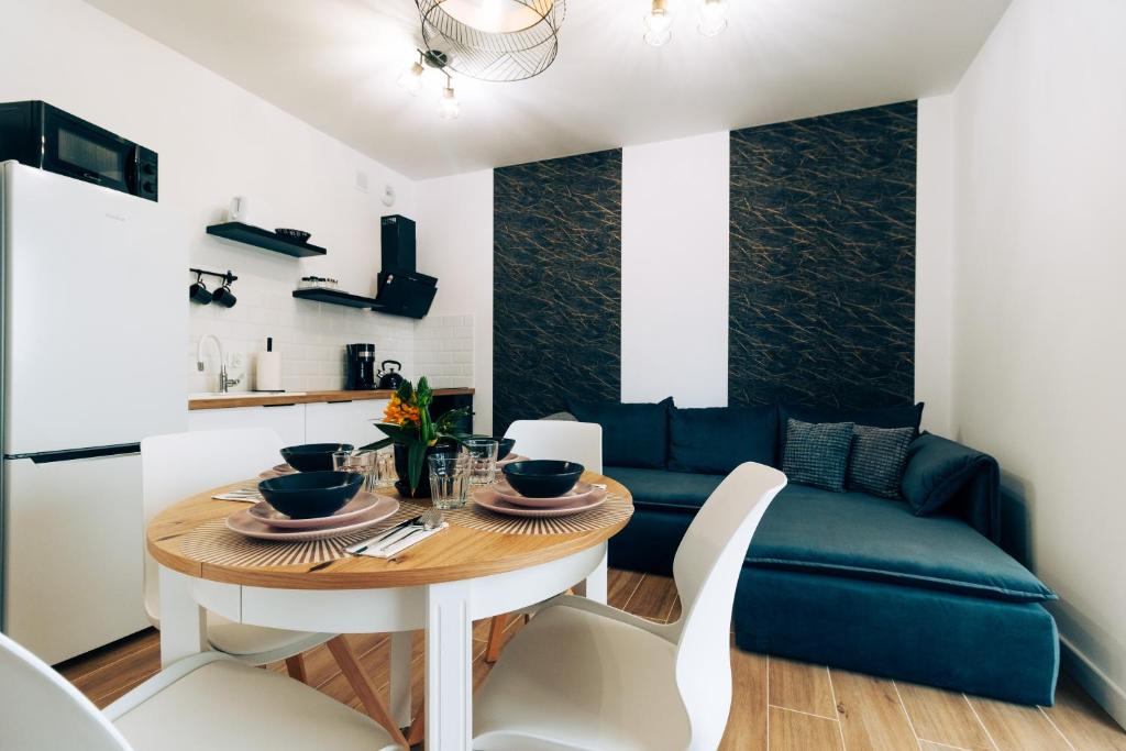 een eetkamer met een tafel en een bank bij Apartament Marbud 2 przy Aquaparku Reda in Rumia