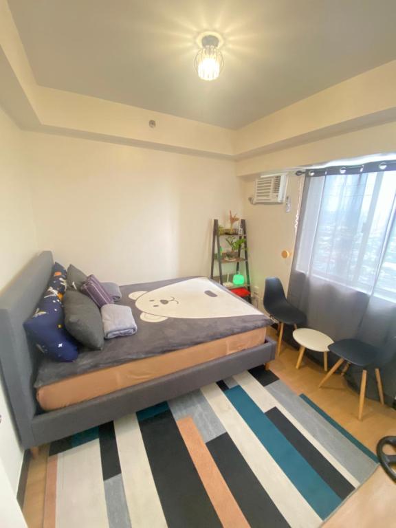 a small bedroom with a bed and a desk at 1 BR Condo Unit at The Celandine Condominium near Ayala Cloverleaf Mall in Manila