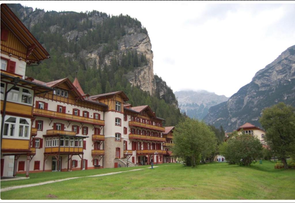 un gruppo di edifici di fronte a una montagna di Mansarda Élite Villaggio Ploner a Dobbiaco