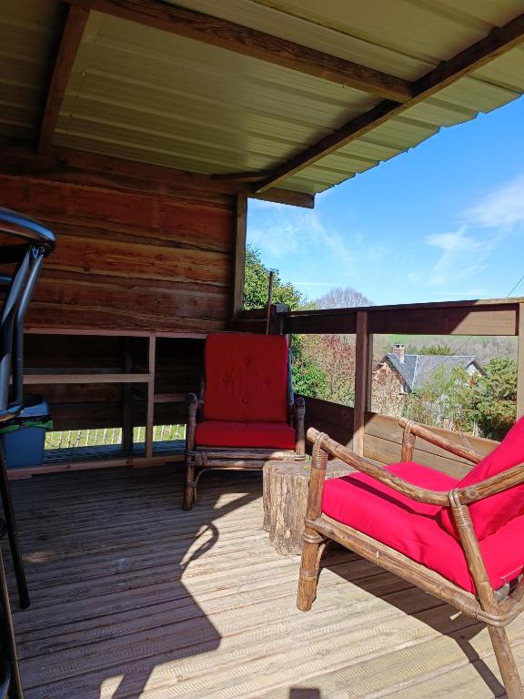 a porch with two chairs on a wooden deck at Chabatz d entraz in Lubersac