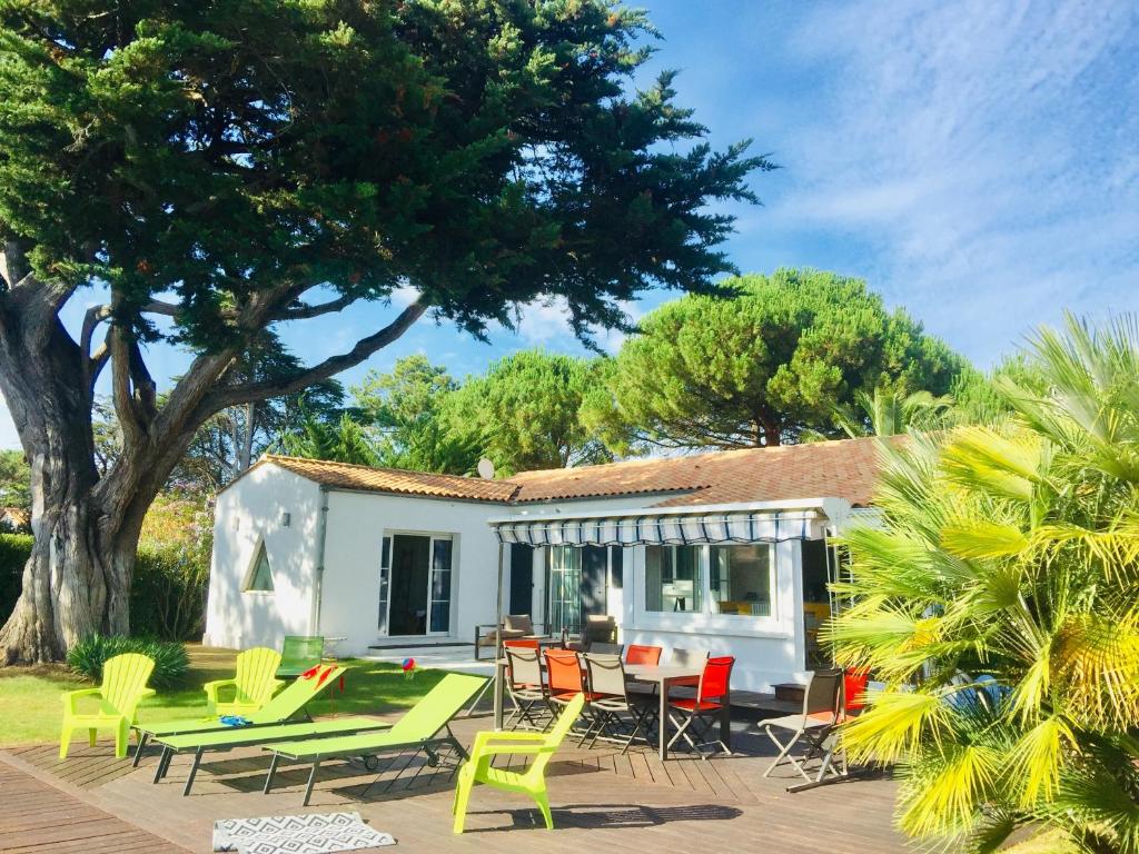 Casa con patio con sillas y mesa en La Taniere, piscine et 300m de la mer, en Saint-Georges-dʼOléron