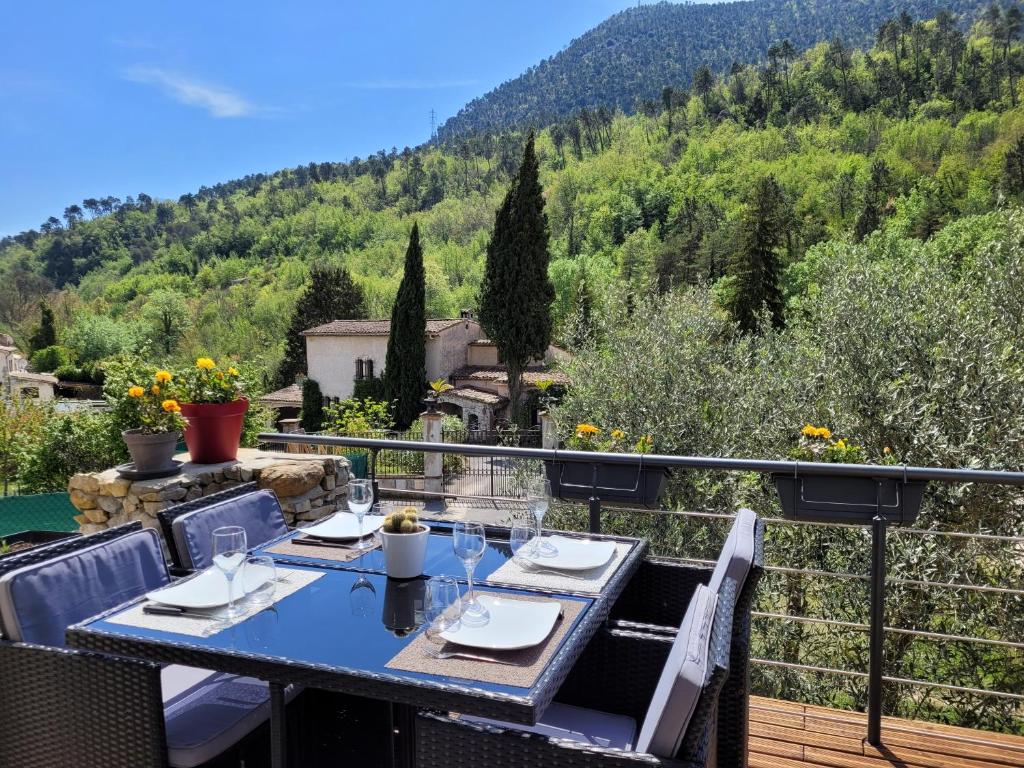 einen Tisch auf einem Balkon mit Bergblick in der Unterkunft Chaleureuse bergerie rénovée. in Tourrette-Levens