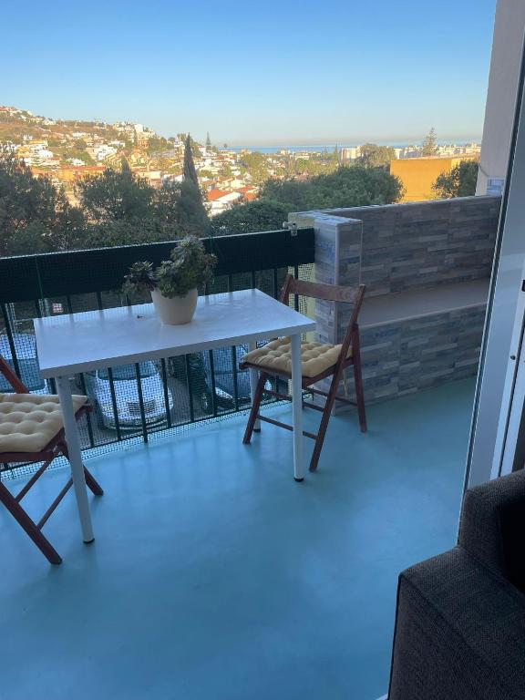 林孔德拉維克托里亞的住宿－Habitación privada en Rincón，阳台上配有一张白色的桌子和两把椅子