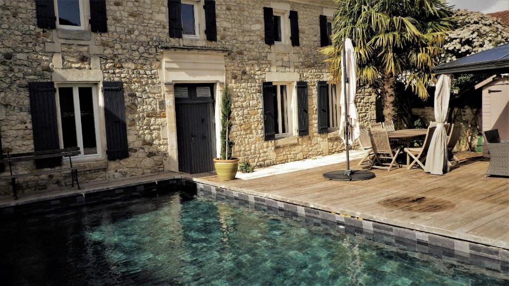 una piscina frente a un edificio con una casa en Le Logis du Breuil - Piscine privee, en Saujon