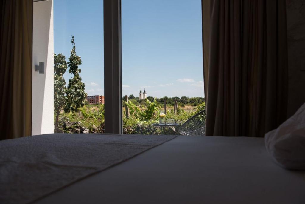 Un dormitorio con una cama y una ventana con vistas. en Tiny guest house in peaceful part of Međugorje, en Međugorje