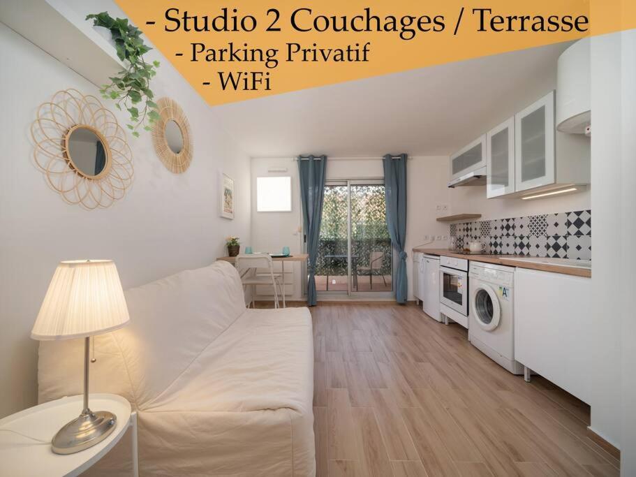 a living room with a white couch and a kitchen at Appartement tout équipé terrasse parking privatif in Six-Fours-les-Plages