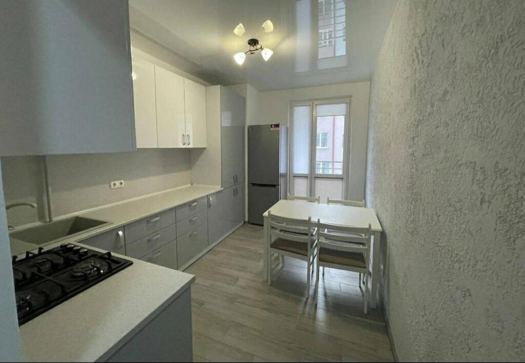 a kitchen with a counter and a table in it at Apartment COMFORT on Ruska street in Chernivtsi