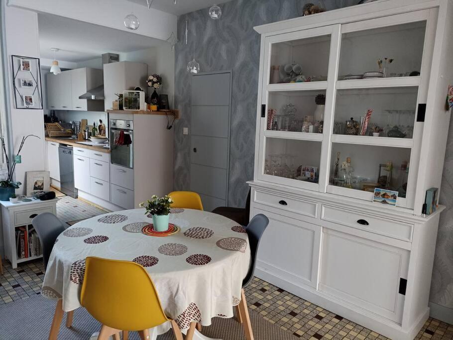 a kitchen with a table with chairs and a white cabinet at B&B during the 24Hours week / Le Mans Legend in Le Mans