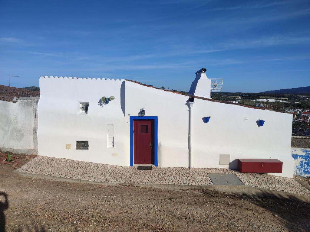 a white building with a red door at 10 da Muralha in Estremoz