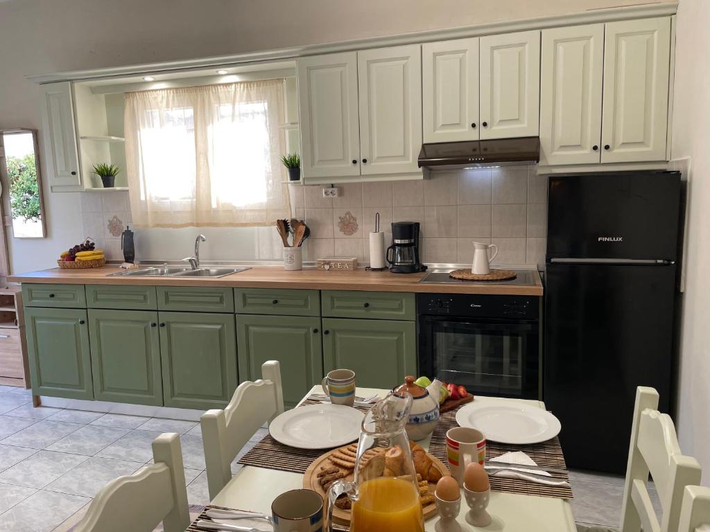 a kitchen with green cabinets and a table with food on it at Villa Agathi in Roda