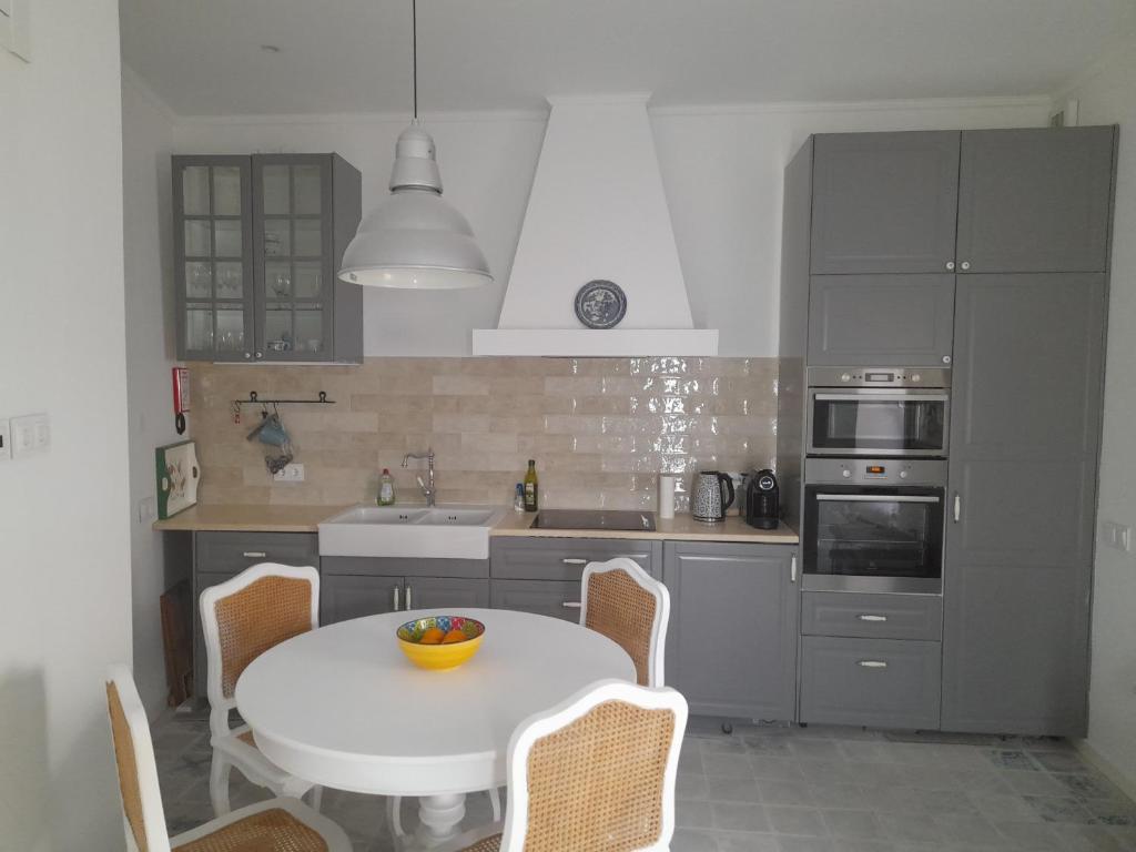 a kitchen with a white table and chairs in it at Casa Rosa in Olhão
