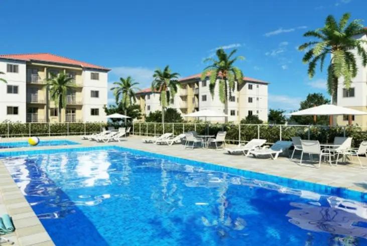 a swimming pool with chairs and tables and buildings at Apartamento Ideal Flores in Manaus