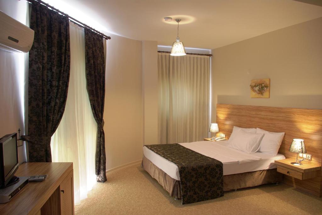a hotel room with a bed and a television at Nevada Hotel & Spa in Fethiye