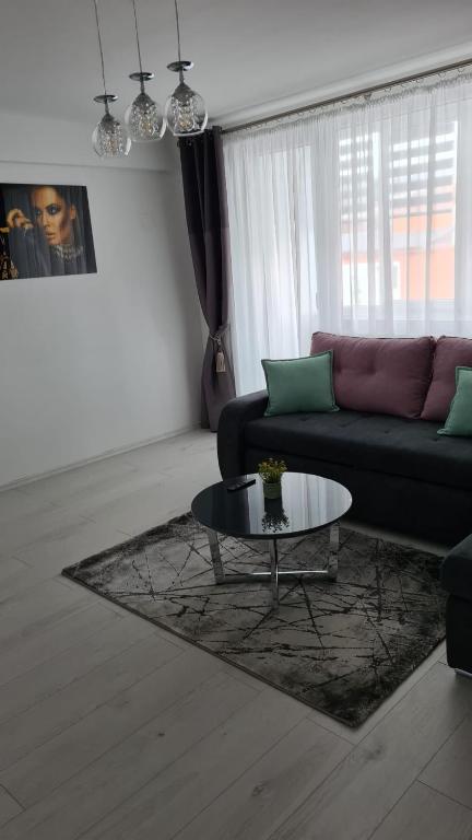 a living room with a couch and a coffee table at Iggy Luxury Central Apartment in Hunedoara