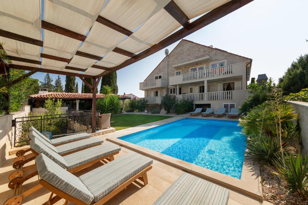 un patio trasero con piscina y una casa en Serviced Family Suite by the sea, Mezaninе lеvеl en Bol