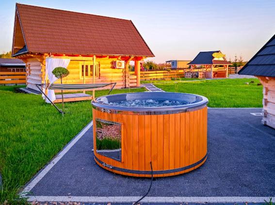 bañera de hidromasaje grande frente a una cabaña en Nini House Dudki, en Giże