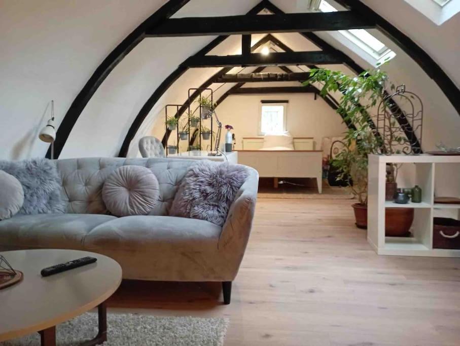 a living room with a couch and an attic at Loft in Flensburgs Zentrum in Flensburg