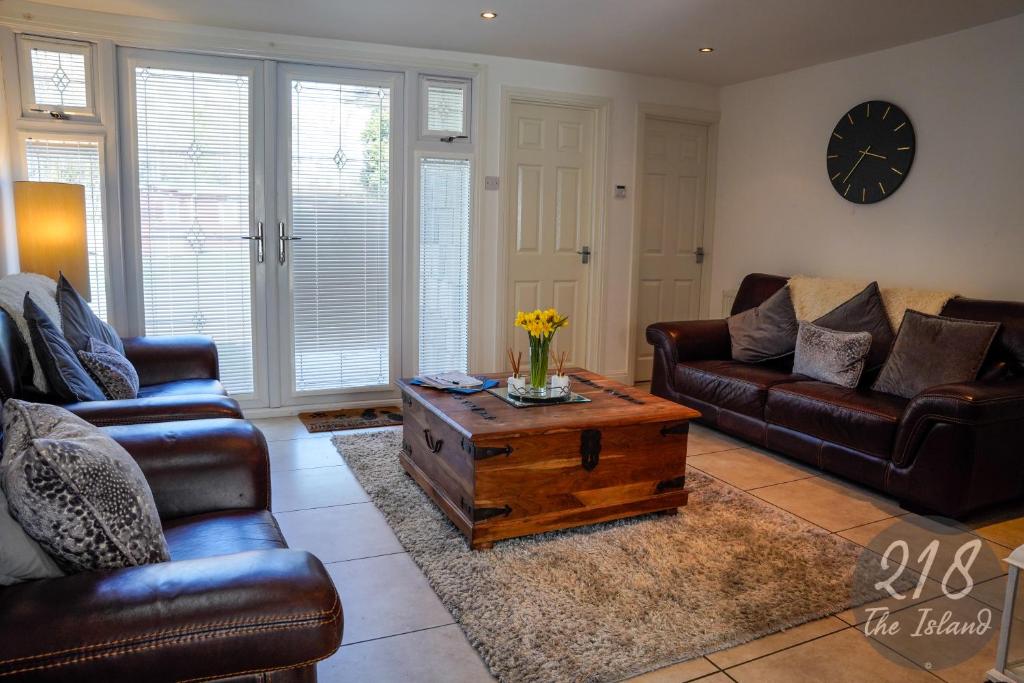 a living room with leather furniture and a coffee table at The Cabin, Glan Gwna in Caernarfon