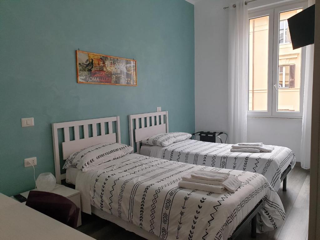 due letti in una stanza con pareti blu di Holidays in Rome - Guesthouse a Roma