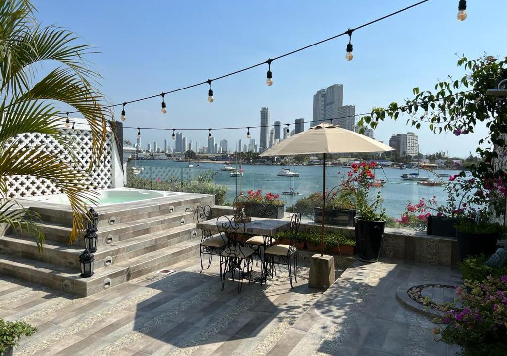 un patio con una mesa con sillas y una sombrilla en Hotel Dorado Plaza Calle del Arsenal, en Cartagena de Indias