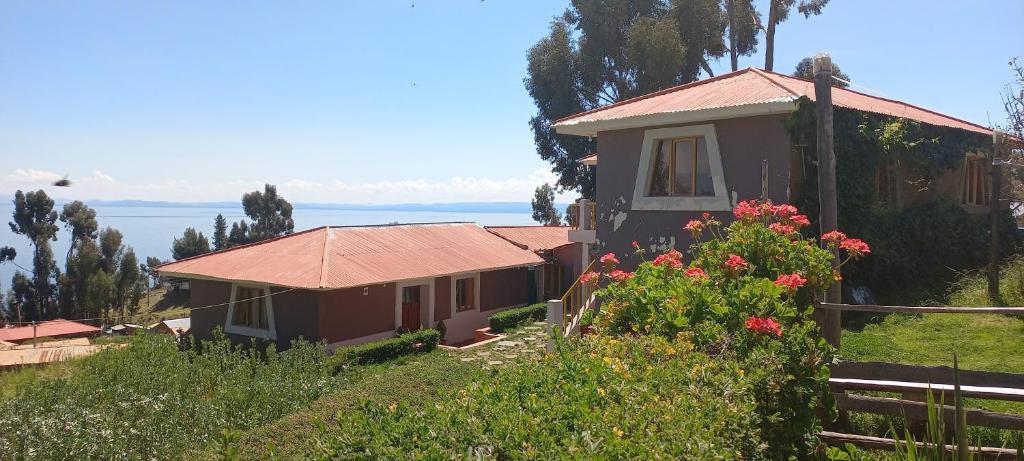 a house on a hill with a view of the water at Musiña Lodge in Amantani
