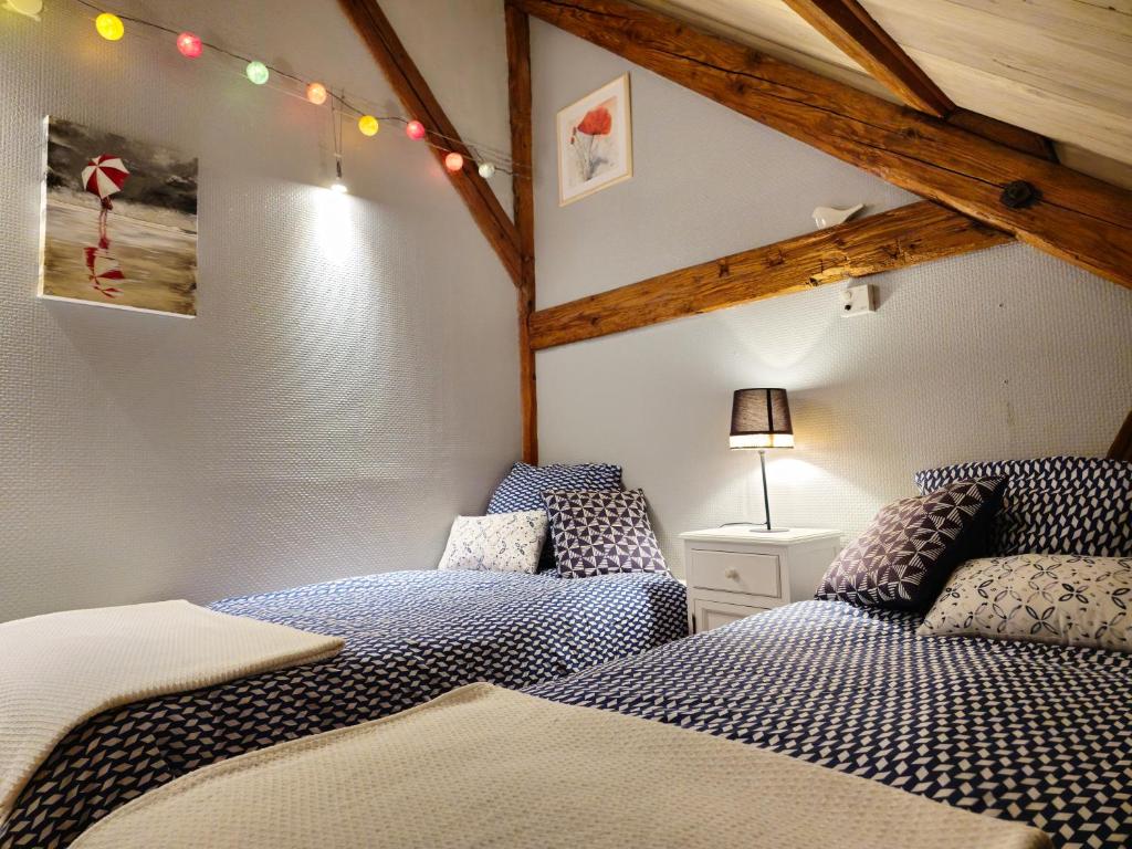 um quarto com 2 camas num sótão em La Maison Rouge Au coeur de la ville. em Riquewihr