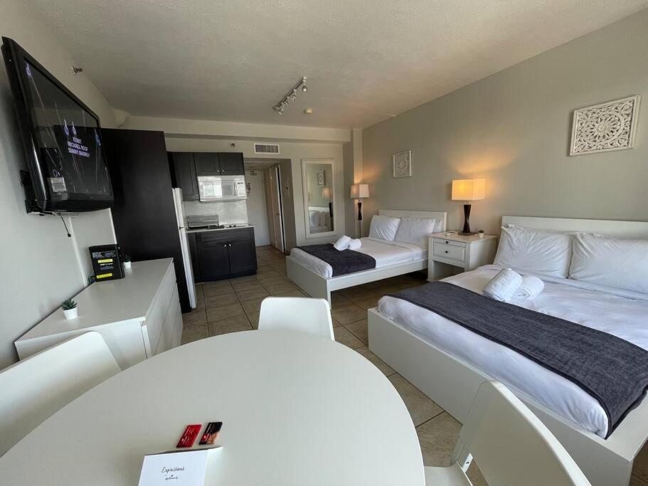 Cette chambre comprend deux lits et une télévision. dans l'établissement Charming Studio City View!, à Miami Beach