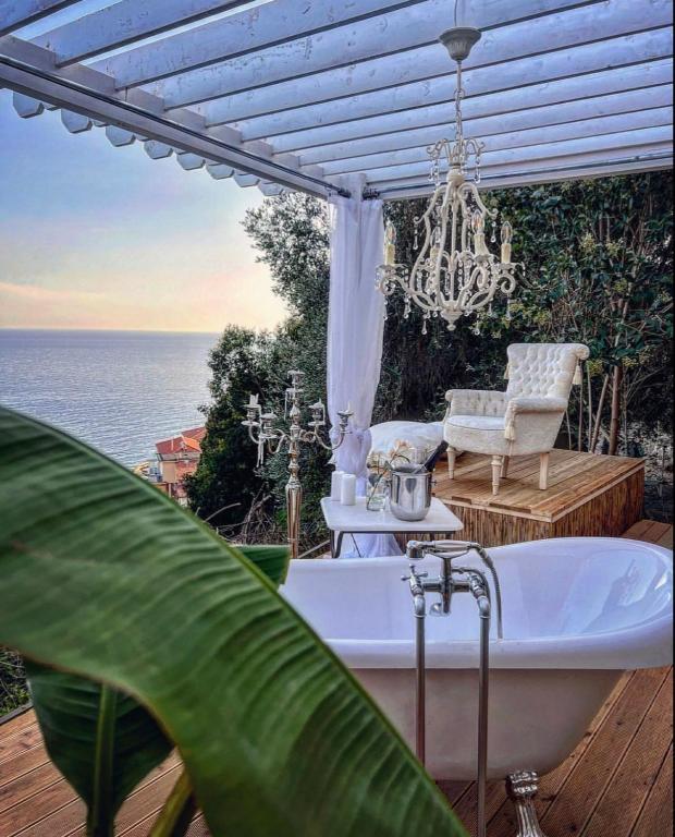 a bath tub on a deck with a chandelier at Luxury Villa Ciao Cocoa in Grimaldi