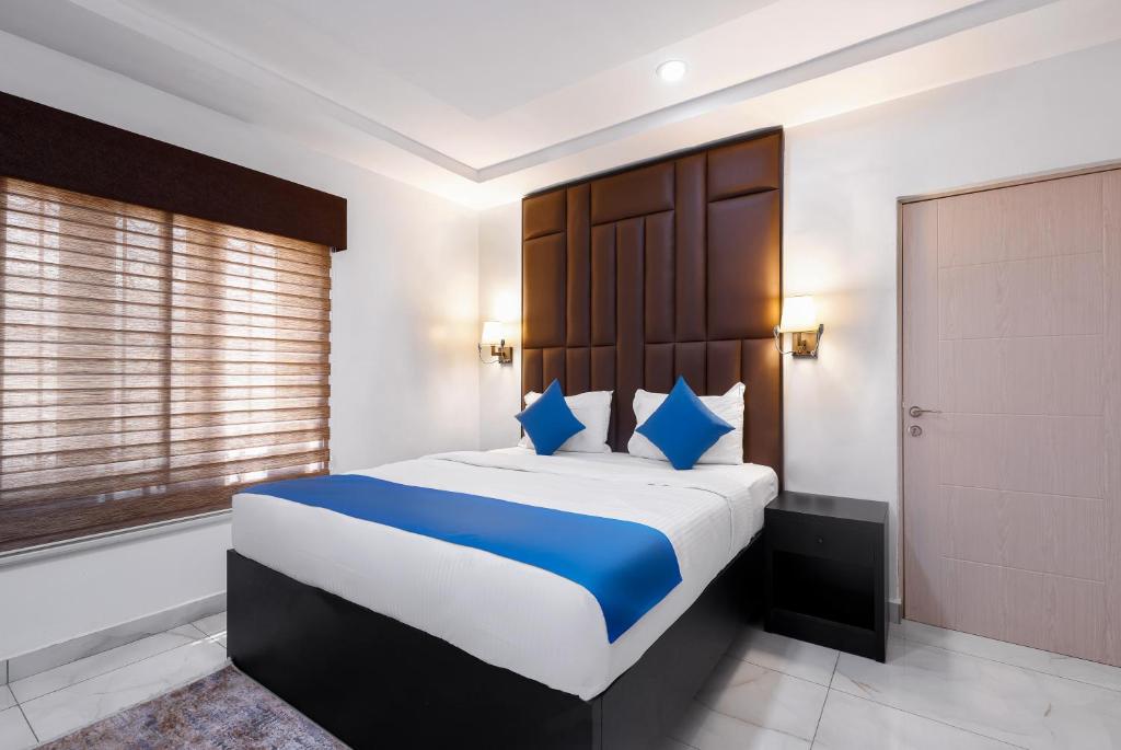 a bedroom with a large bed with blue pillows at BKT Cribs - Apartments & Suites in Abuja