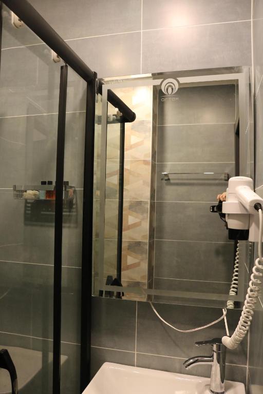 La salle de bains est pourvue d'une douche, d'un lavabo et d'un téléphone. dans l'établissement Aura Hotel Taksim, à Istanbul