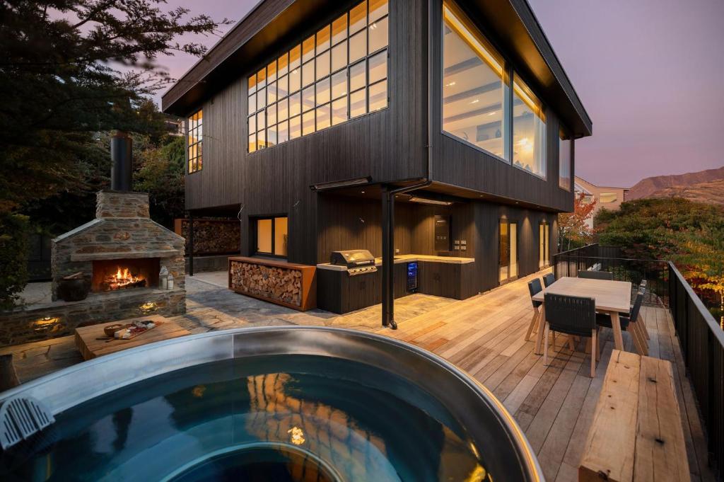 een huis met een zwembad en een open haard bij Lakeside Terrace Luxury by Relaxaway Holiday Homes in Queenstown