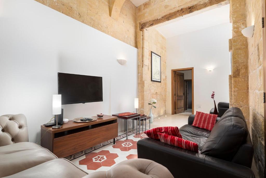 a living room with two couches and a flat screen tv at Traditional & Modern Maltese Townhouse - Rooftop Terrace and Sea Views, close to Birgu Waterfront in Cospicua