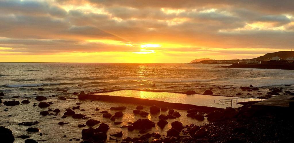 un grupo de personas en una playa al atardecer en Altillo Vista Mar, en Moya