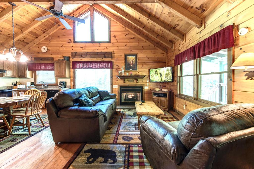 ein Wohnzimmer mit Sofas und einem Kamin in einer Hütte in der Unterkunft Fawn Cabin, 1 Bedroom, Sleeps 4, Hot Tub, Private, Pets, Gas Fireplace in Gatlinburg
